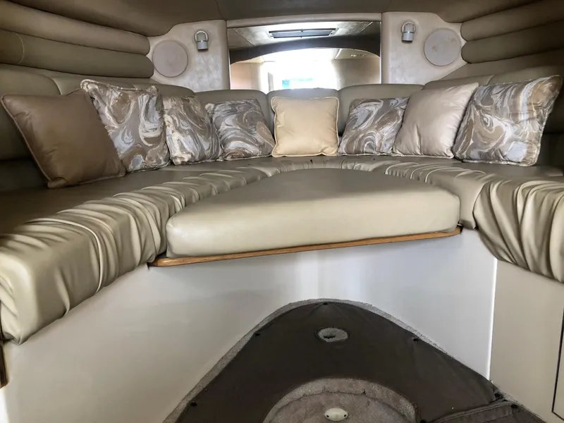 Slide: The Image of Interior of 1998 Sea Ray 290 Sundancer with beige seating and decorative pillows. - 5