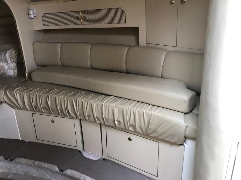 Slide: The Image of 1998 Sea Ray 290 Sundancer interior with beige leather seating and storage cabinets. - 6