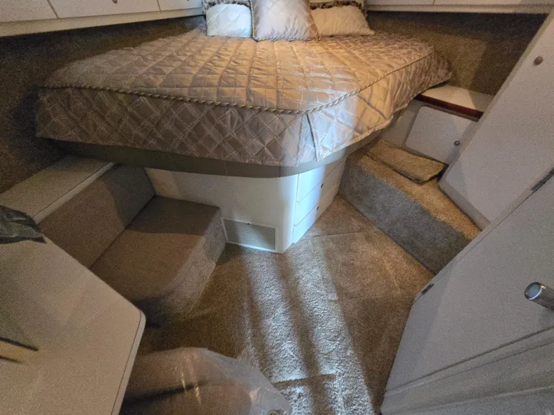 Slide: The Image of 1996 Silverton 37 Convertible cabin interior with bed, carpeted floor, and seating area. - 12