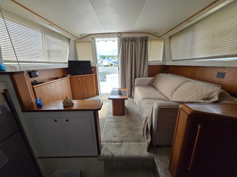 Slide: The Image of Interior of a 1996 Silverton 37 Convertible yacht with cozy seating and modern amenities. - 16