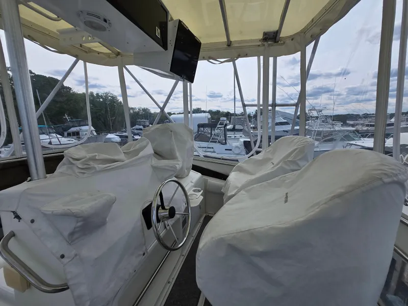 Slide: The Image of 1996 Silverton 37 Convertible boat interior with covered seats and steering wheel. - 23