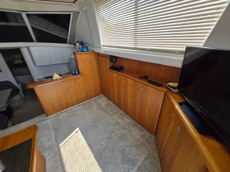 Slide: The Image of Interior of 1996 Silverton 37 Convertible yacht with wood cabinets and TV. - 3