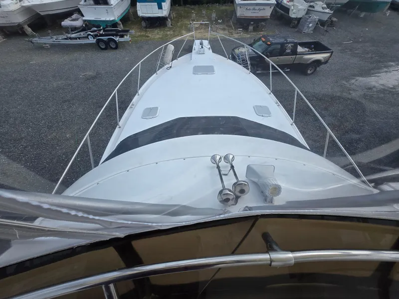 Slide: The Image of 1996 Silverton 37 Convertible boat viewed from above, parked on gravel with other boats nearby. - 36