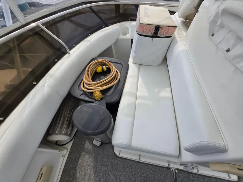 Slide: The Image of 1996 Silverton 37 Convertible boat interior with white seating and coiled hose. - 39