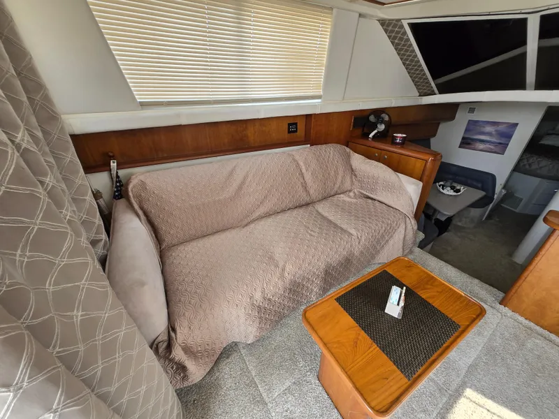 Slide: The Image of Interior of 1996 Silverton 37 Convertible yacht with cozy seating and wooden accents. - 4