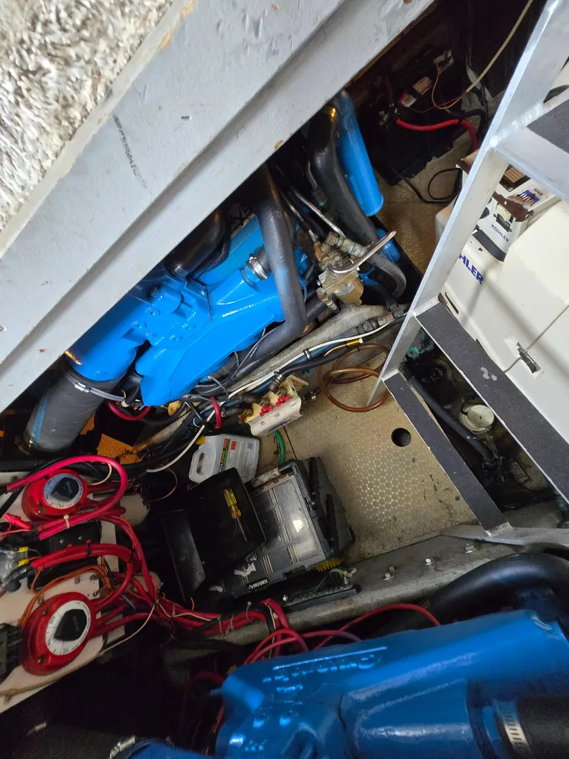 Slide: The Image of Engine room of a 1996 Silverton 37 Convertible boat, showcasing blue engine and wiring. - 44