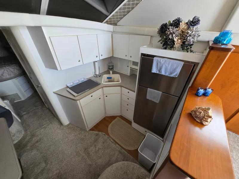 Slide: The Image of 1996 Silverton 37 Convertible yacht kitchen with white cabinets and stainless steel appliances. - 5