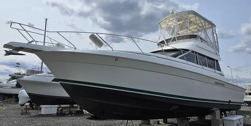 Slide: The Image of 1996 Silverton 37 Convertible boat on dry dock under cloudy sky. - 52