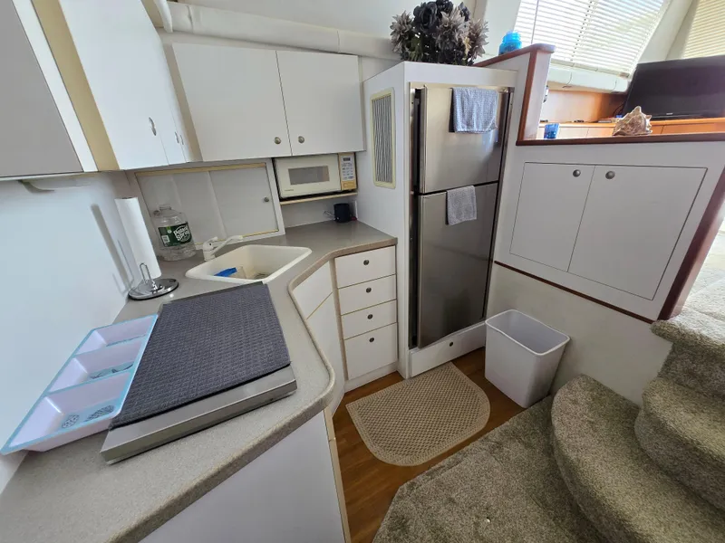 Slide: The Image of 1996 Silverton 37 Convertible yacht kitchen with modern appliances and white cabinetry. - 8