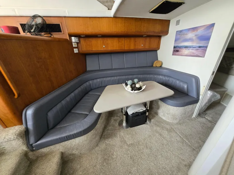 Slide: The Image of 1996 Silverton 37 Convertible interior with gray seating, table, and wall art. - 9