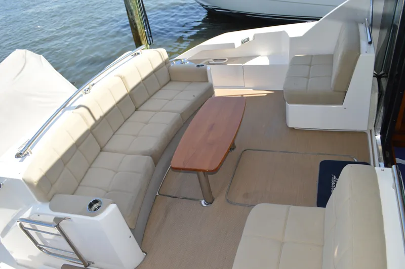 Slide: The Image of Luxurious seating area on 2016 Tiara Yachts C44 Coupe with beige cushions and wooden table. - 14