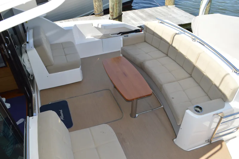 Slide: The Image of 2016 Tiara Yachts C44 Coupe cockpit with beige seating and wooden table. - 15
