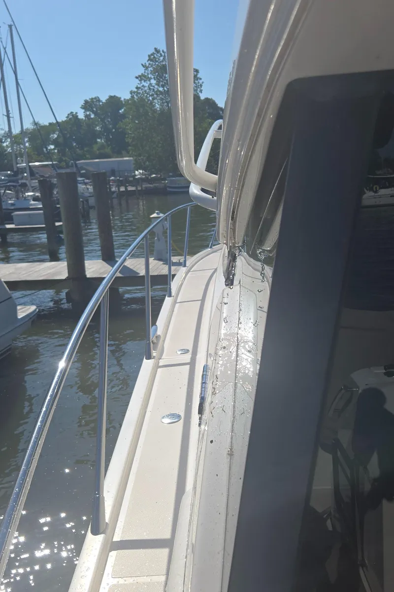 Slide: The Image of 2016 Tiara Yachts C44 Coupe docked at marina, side view with railing and water. - 22