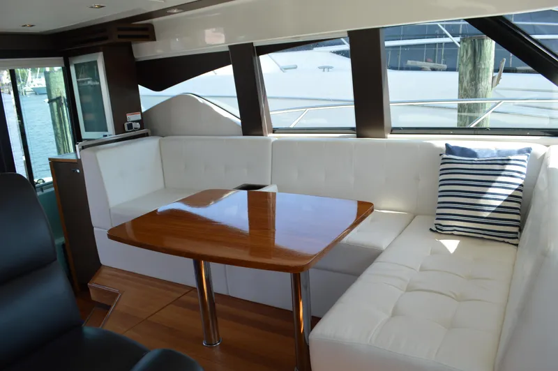 Slide: The Image of Interior of 2016 Tiara Yachts C44 Coupe with white seating and wooden table. - 31