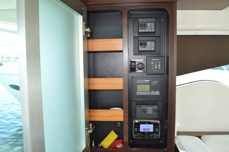 Slide: The Image of Control panel inside 2016 Tiara Yachts C44 Coupe, featuring various electronic systems and storage shelves. - 38