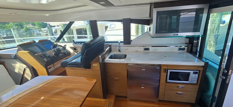 Slide: The Image of Interior of 2016 Tiara Yachts C44 Coupe with helm, kitchen, and modern amenities. - 42