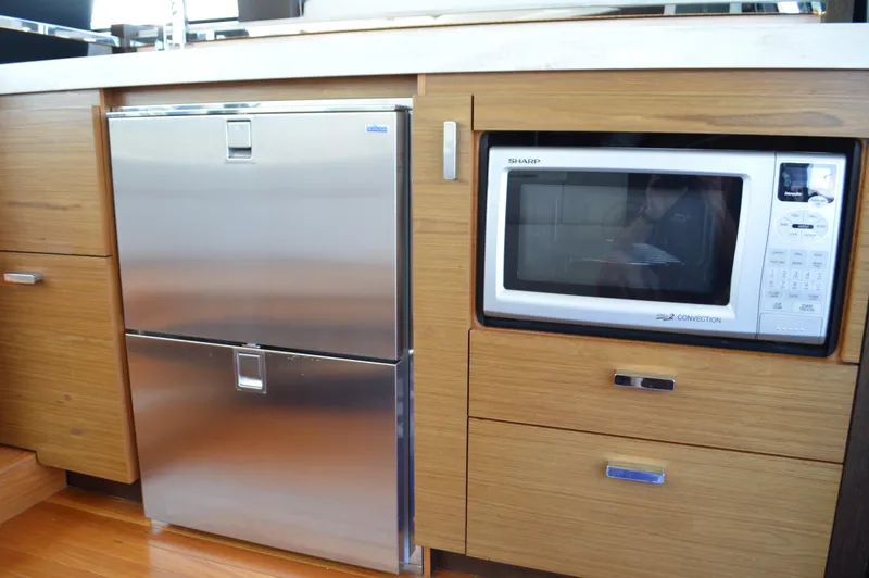 Slide: The Image of Kitchen area in 2016 Tiara Yachts C44 Coupe with microwave and stainless steel fridge. - 44