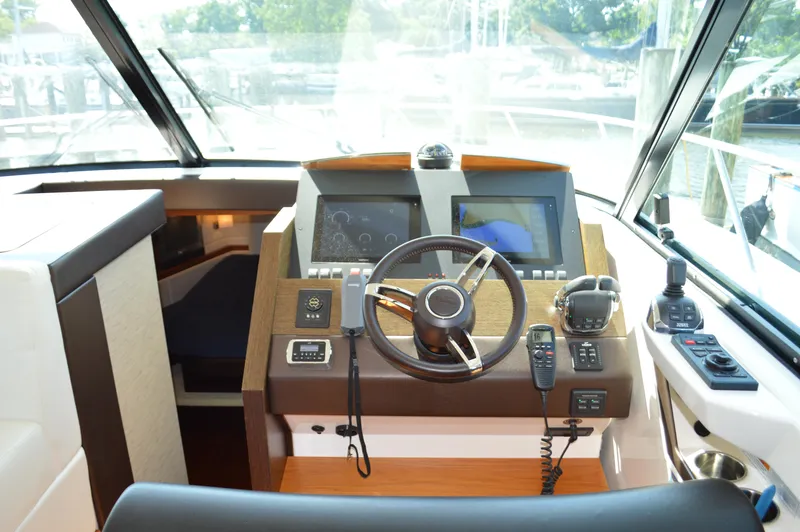 Slide: The Image of 2016 Tiara Yachts C44 Coupe helm with modern navigation controls and steering wheel. - 48
