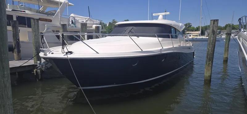 Slide: The Image of 2016 Tiara Yachts C44 Coupe docked in a marina under clear blue skies. - 5
