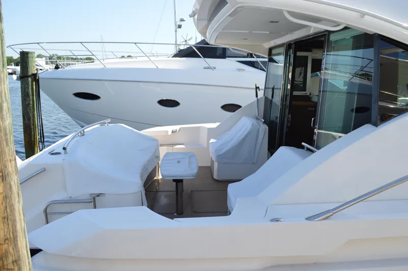 Slide: The Image of 2016 Tiara Yachts C44 Coupe, docked with covered seating area and sleek design. - 9