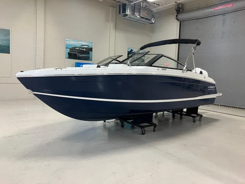 Slide: The Image of 2025 Cobalt R4 Outboard boat in showroom, featuring sleek design and navy blue hull. - 4