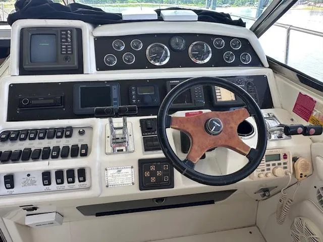 Slide: The Image of 1995 Sea Ray 400 Express Cruiser helm with gauges, controls, and wooden steering wheel. - 14