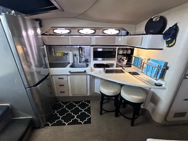 Slide: The Image of Interior of 1995 Sea Ray 400 Express Cruiser kitchen with modern appliances and seating. - 18