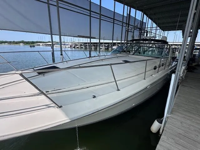 Slide: The Image of 1995 Sea Ray 400 Express Cruiser docked in a marina under a covered area. - 4