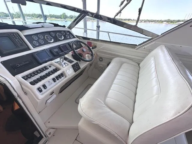 Slide: The Image of 1995 Sea Ray 400 Express Cruiser cockpit with white leather seating and control panel. - 6