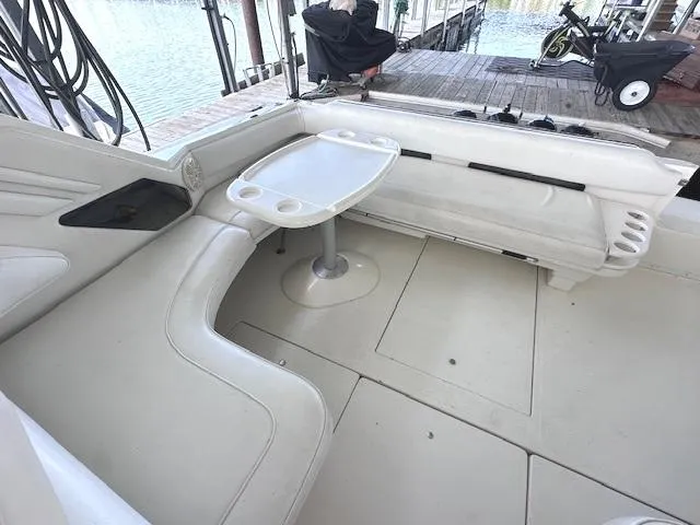 Slide: The Image of 1995 Sea Ray 400 Express Cruiser interior with white seating and table, dockside view. - 7