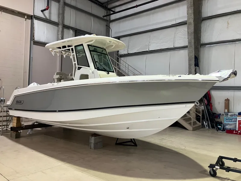 The Image of 2025 Boston Whaler 250 Outrage boat in a warehouse, showcasing sleek design and modern features. - 0