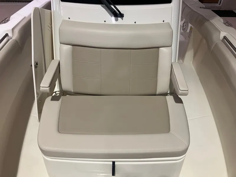 Slide: The Image of 2025 Boston Whaler 250 Outrage boat seat with beige upholstery and armrests. - 11