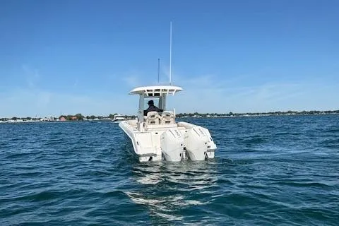 Slide: The Image of 2025 Boston Whaler 250 Outrage cruising on open water under clear blue sky. - 38