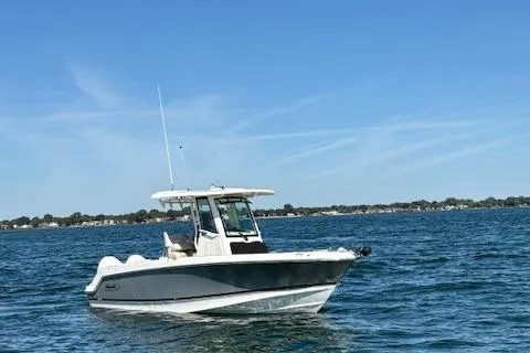 Slide: The Image of 2025 Boston Whaler 250 Outrage boat on open water under clear blue sky. - 43