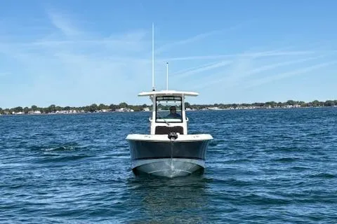 Slide: The Image of 2025 Boston Whaler 250 Outrage boat on open water under clear blue sky. - 44