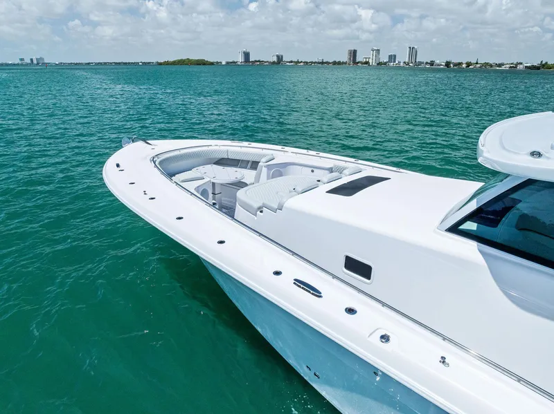 Slide: The Image of 2025 HCB 56' Sueños GIX yacht on turquoise water, city skyline in background. - 11