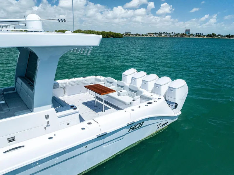Slide: The Image of 2025 HCB 56' Sueños GIX luxury boat on clear blue water, featuring multiple engines. - 12