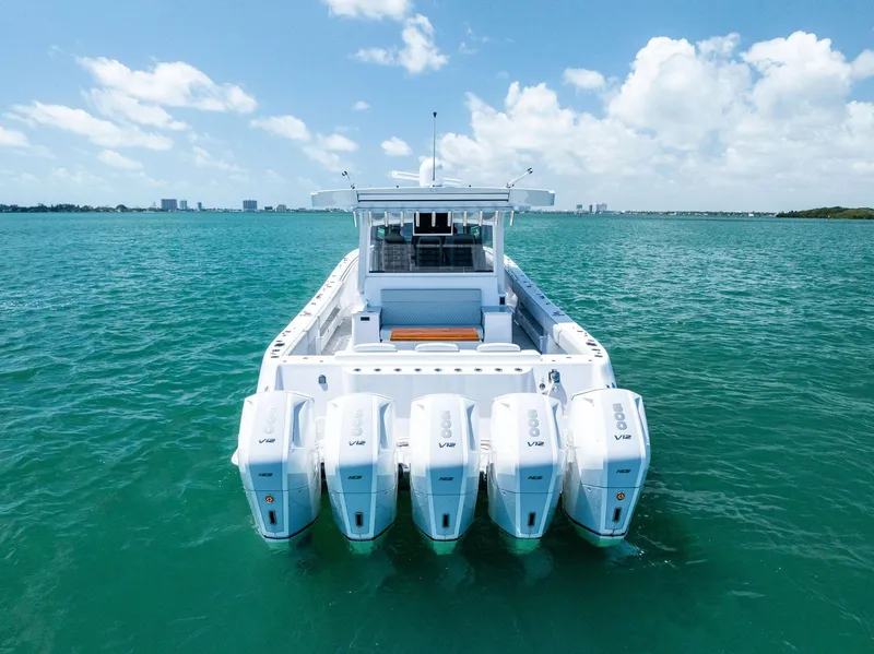 Slide: The Image of 2025 HCB 56' Sueños GIX luxury boat with five powerful outboard engines on open water. - 13