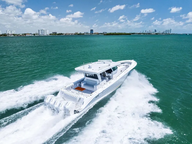 Slide: The Image of 2025 HCB 56' Sueños GIX cruising on turquoise waters under a clear blue sky. - 2
