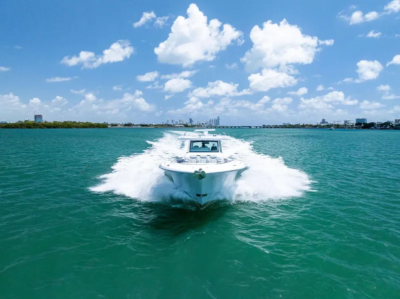 Slide: The Image of HCB 56' Sueños GIX 2025 cruising on turquoise water under a clear blue sky. - 3