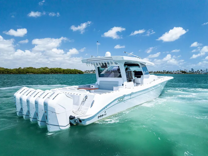 Slide: The Image of 2025 HCB 56' Sueños GIX luxury boat cruising on clear blue water under a sunny sky. - 4