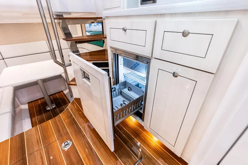 Slide: The Image of Luxurious interior of 2025 HCB 56' Sueños GIX yacht with open fridge and elegant wood flooring. - 47