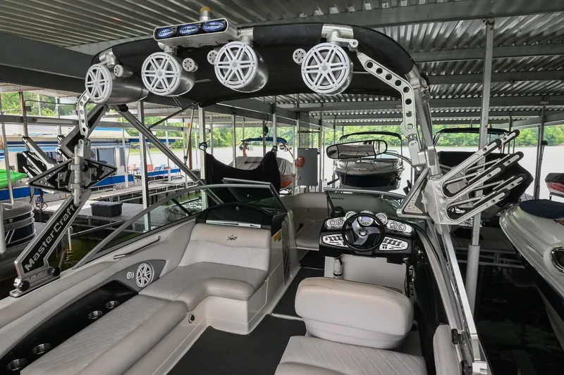 Slide: The Image of 2009 MasterCraft X-45 boat interior with speakers and seating under a covered dock. - 21