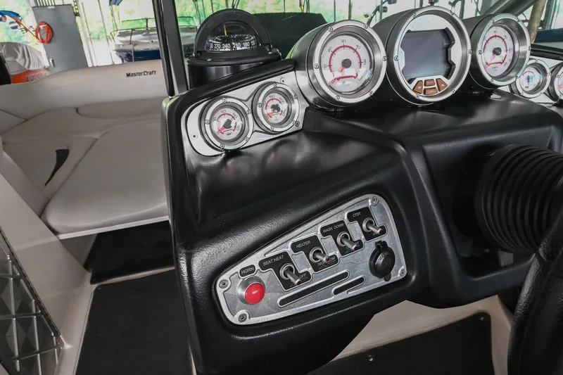Slide: The Image of 2009 MasterCraft X-45 dashboard with gauges and controls in a sleek black design. - 29