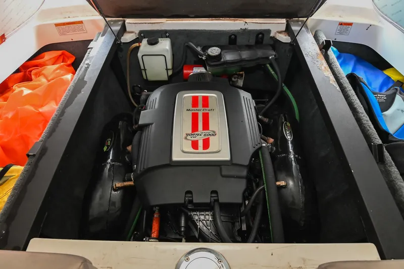 Slide: The Image of 2009 MasterCraft X-45 engine compartment with visible components and colorful storage items. - 42
