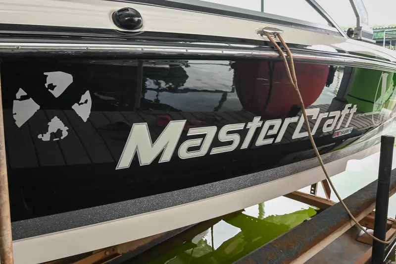 Slide: The Image of 2009 MasterCraft X-45 boat docked, showcasing sleek black design and logo. - 6