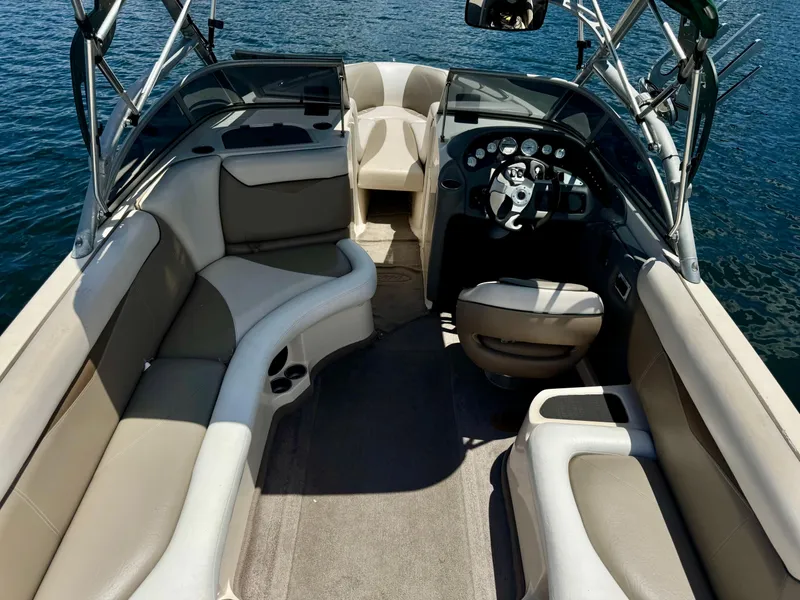 Slide: The Image of 2005 Tigé 24V boat interior with beige seating and steering wheel, on calm water. - 10