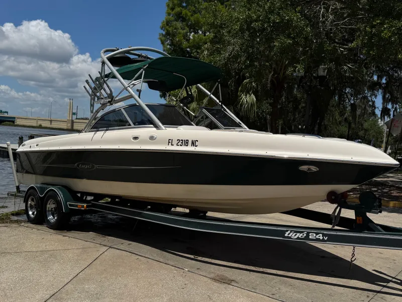 Slide: The Image of 2005 Tigé 24V boat on trailer, parked near a waterfront under a clear blue sky. - 13