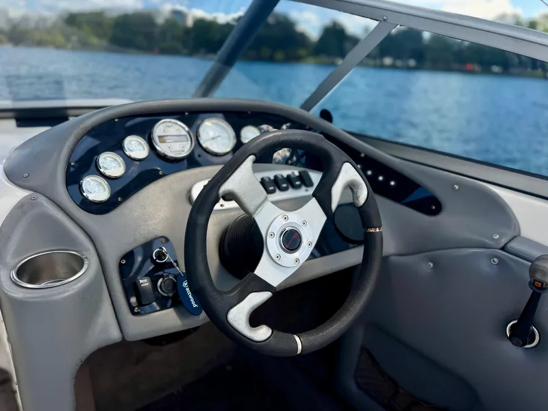 Slide: The Image of 2005 Tigé 24V boat dashboard with steering wheel, gauges, and lake view. - 3