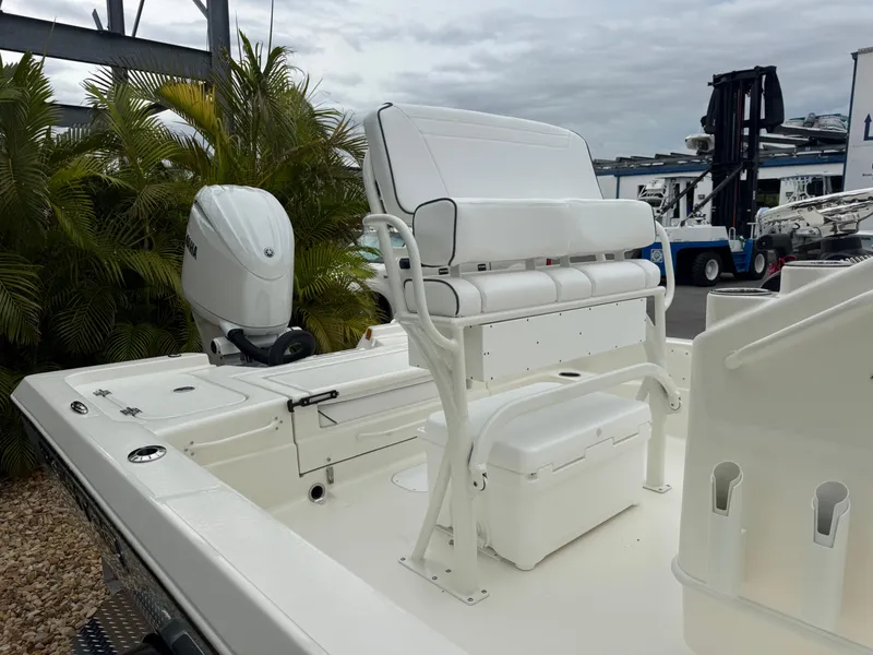 Slide: The Image of 2025 Skeeter SX 221 boat with seating and outboard motor, docked near lush greenery. - 10